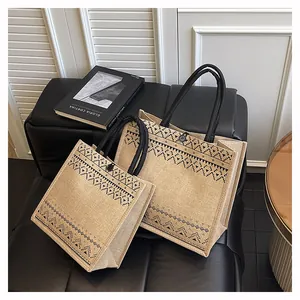 Eco-friendly natural jute tote bags with chic black geometric patterns in two sizes.