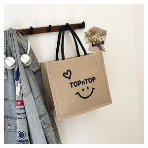 Close-up of a large capacity burlap tote bag with TopnTop print hanging on a hook