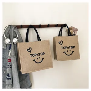 Eco-friendly printed burlap tote bags hanging on a wooden wall rack in a home setting