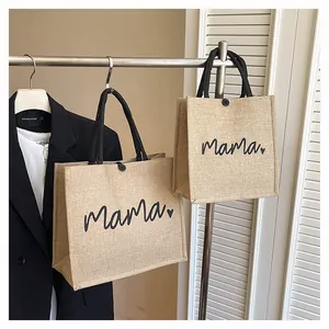 Lifestyle view of two rustic jute tote bags featuring 'Mama' text and heart print.