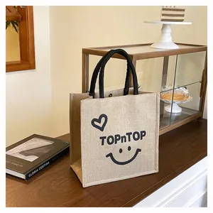 Stylish jute burlap tote bag with TOPnTOP print in a cozy cafe setting for daily use