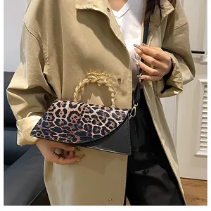 Detailed view of the vintage leopard print crossbody bag with elegant gold metal handle