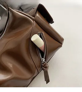 Nahaufnahme der braunen Vintage-Ledertasche mit funktionaler Reißverschlusstasche vorne.