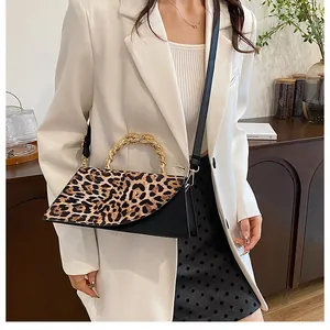 Detail of retro leopard print crossbody bag with stylish gold twisted metal handle