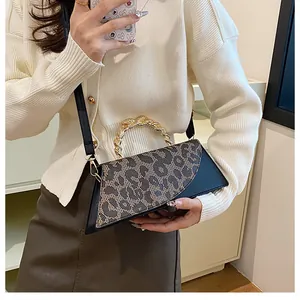 Detailed view of leopard print crossbody bag with elegant gold metal chain handle