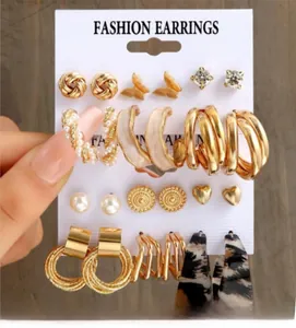 Set di orecchini alla moda con cerchi dorati e perni di perle su espositore