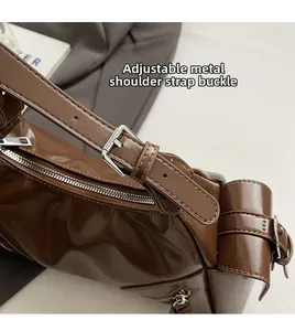 Detailansicht der verstellbaren silbernen Metallschnalle an einer braunen Ledertasche