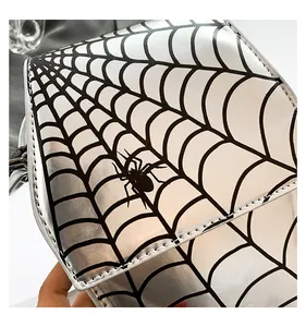 Primo piano di una piccola borsa stile dark con stampa creativa a ragnatela e ragno.