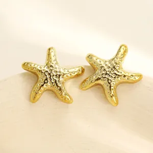 Vista macro dettagliata di eleganti orecchini a lobo a forma di stella marina color oro