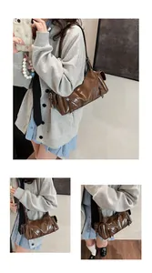 Detailaufnahmen einer braunen Vintage-Motorradtasche aus weichem Leder am Model getragen