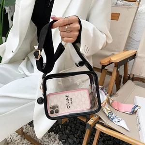 Détail d'un sac à bandoulière transparent en PVC avec sangle noire et foulard en soie