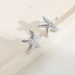 Macro dettagliata di orecchini a stella marina argento con texture