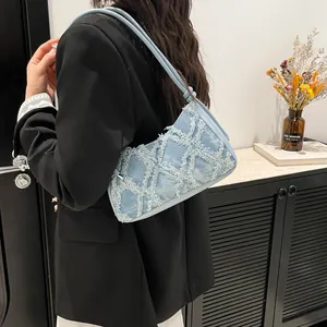 Trendy denim underarm bag for women with frayed diamond pattern and chic shoulder strap.