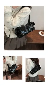 Detailansicht einer glänzenden schwarzen Motorrad-Hobo-Tasche mit Metallreißverschlüssen.