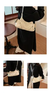 Detailansicht eines Models mit einer beigen Retro-Hobo-Tasche aus weichem Leder.