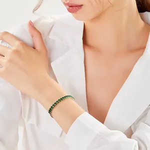 Bracelet élégant en zircone marquise vert émeraude au poignet, détail plaqué or