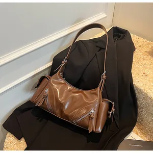 Detailansicht einer glänzenden braunen Retro-Unterarmtasche aus weichem Leder für Damen.