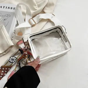 Vue détaillée d'un sac bandoulière en PVC transparent avec large sangle blanche et foulard.