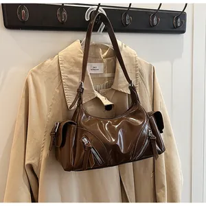 Detailansicht der braunen, glänzenden Biker-Schultertasche aus Leder mit Reißverschlüssen