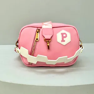 Pink streetwear crossbody bag with white P patch and lightning bolt strap detail