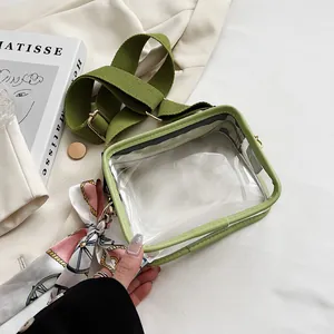 Vue rapprochée de la texture PVC, de la large sangle olive et du foulard en soie