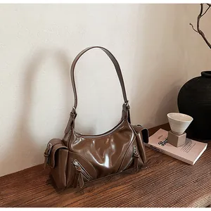Detailansicht einer braunen Vintage-Motorradtasche aus weichem Leder auf einem Holztisch