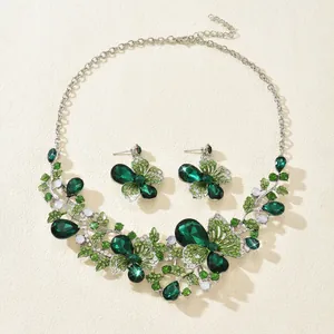 Detailed view of luxury vintage emerald green rhinestone butterfly and floral jewelry set