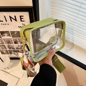 Détail du sac bandoulière en PVC vert transparent avec large sangle et foulard