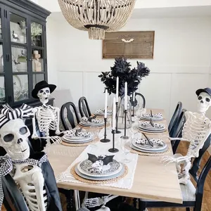 Scena della sala da pranzo di Halloween con scheletri articolati a tavola decorata