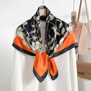 Elegant mulberry silk scarf with floral print and vibrant orange-black color block