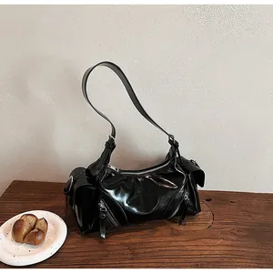 Glänzende schwarze Retro-Biker-Tasche auf einem rustikalen Holztisch für den Alltag