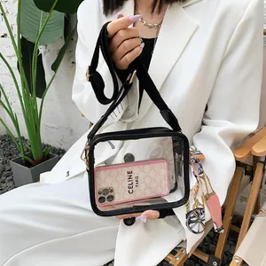Détail d'un sac bandoulière transparent en PVC avec large sangle et foulard en soie