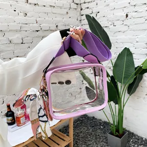 Gros plan d'un sac en PVC transparent avec bordure violette, bandoulière large et nœud