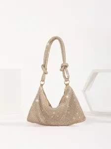Detailed close-up of a luxury gold rhinestone evening bag featuring an elegant knotted handle