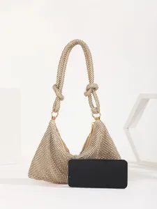 Detailed view of the gold rhinestone evening bag showing size scale next to a smartphone