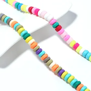 Macro view of multi-colored flat round polymer clay heishi beads for DIY jewelry making.
