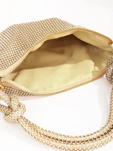 Close-up of gold rhinestone evening bag showing inner fabric lining and zipper detail.
