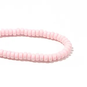 Close-up detail of light pink polymer clay flat round spacer beads for DIY jewelry