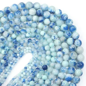 Makroaufnahme von blau-weißen Natursteinperlen mit Marmortextur für DIY-Schmuckherstellung.
