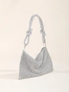 Close-up of elegant silver rhinestone evening bag featuring a unique knotted handle