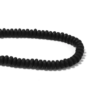 Macro detail of matte black flat round polymer clay spacer beads for DIY jewelry