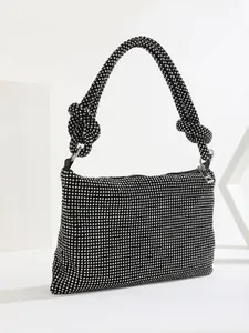 Detailed view of a shimmering black rhinestone evening bag with unique knotted strap design.