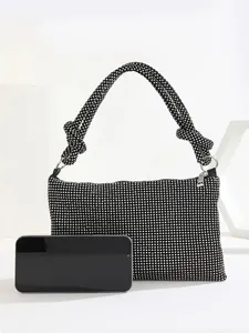 Sparkling black rhinestone evening bag detail with a stylish knotted top handle strap.
