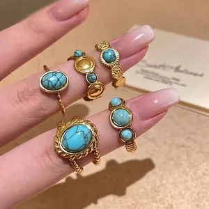 Detailed macro view of vintage gold-tone bohemian rings with faux turquoise stones