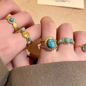 Macro detail of ethnic style golden open rings with turquoise stones for stacking