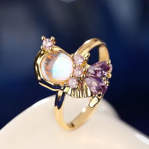 Macro view of fairytale princess ring featuring an iridescent moonstone and purple gems