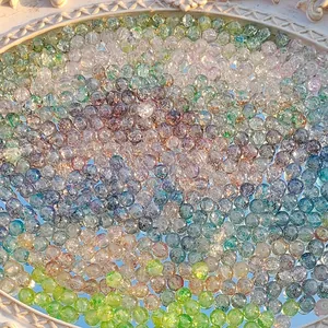 Detail of multi-colored water-dyed glass beads with gold foil and cracked texture.
