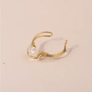 Detailed view of handmade gold wire-wrapped ring with clear natural crystal
