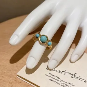 Close-up detail of golden ethnic style open ring with three faux-turquoise stones