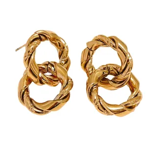 Detail view of gold twisted double hoop earrings with fine metallic texture and design